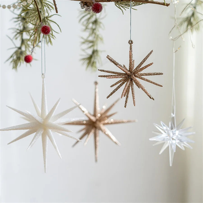 White, champagne and clear starburst ornaments hanging from a pine garland with red berries