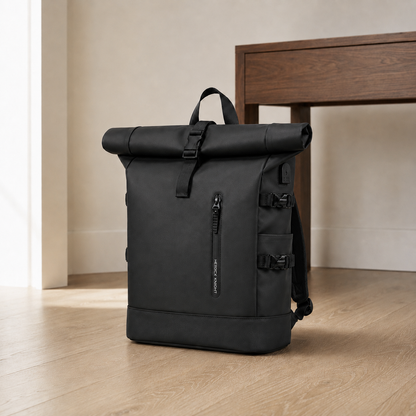 Black roll top backpack standing on the floor of a bright entrance hall beside a walnut console table
