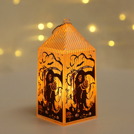 Mini Halloween lantern lit warm amber, printed with a hooded reaper holding a scythe under bare trees