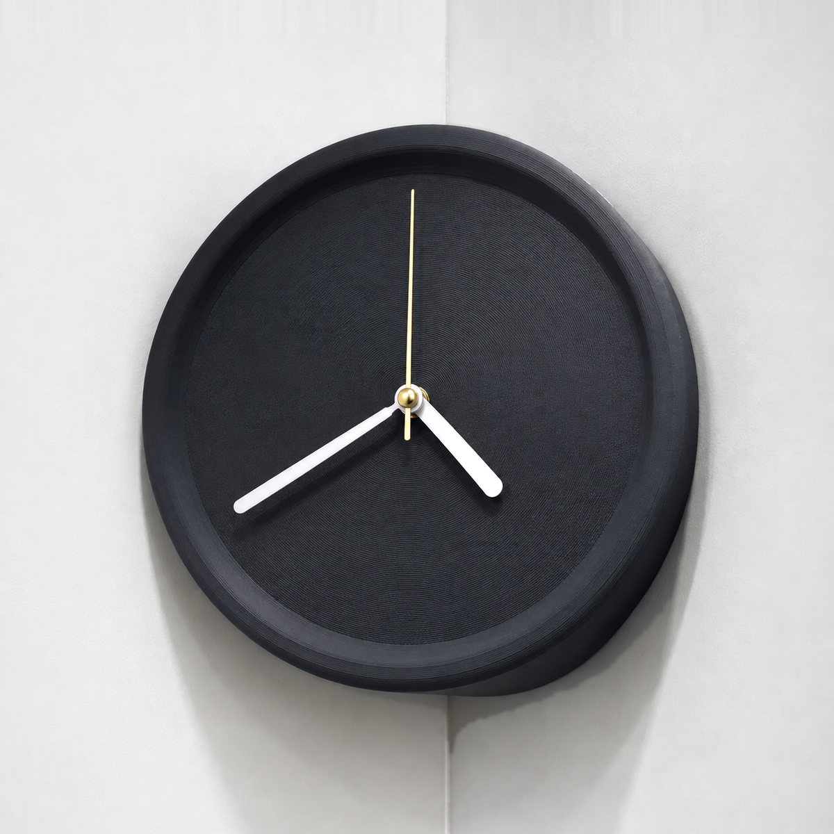 Black corner wall clock hung in an inside wall corner, plain dial with white hands
