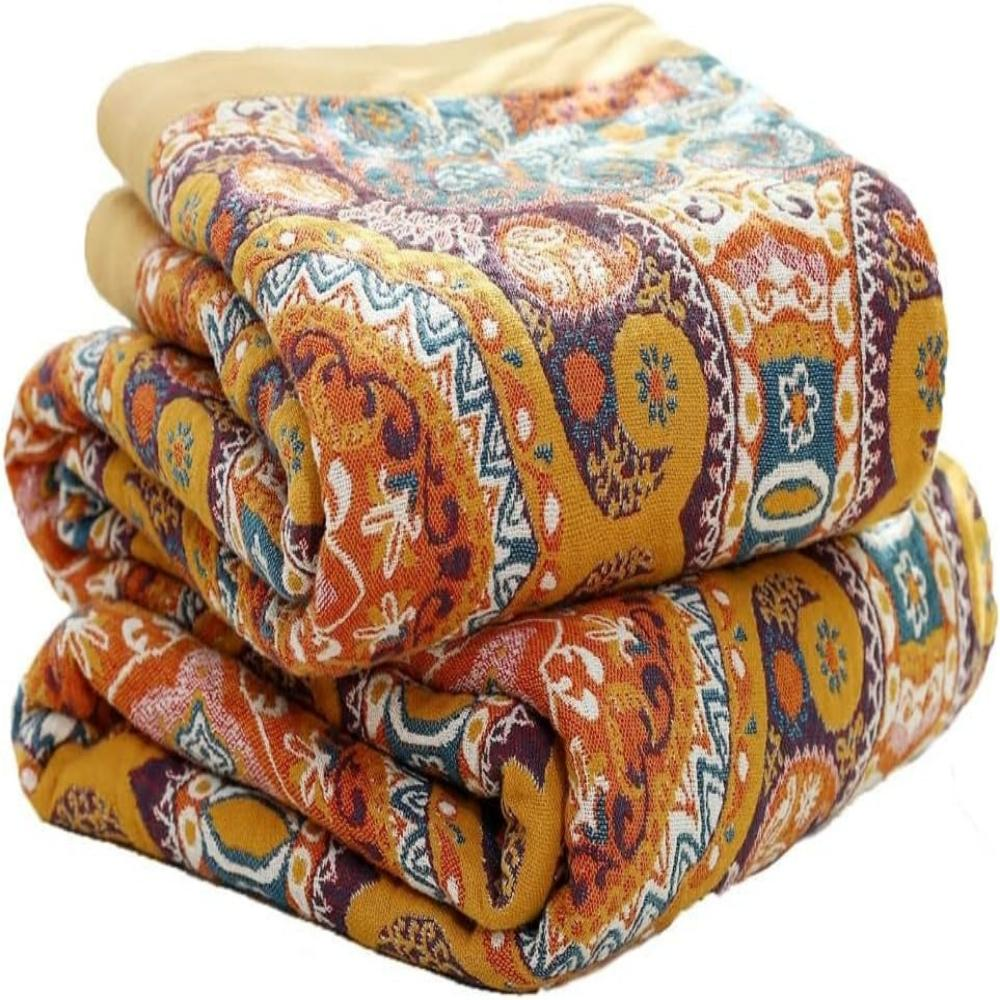 Medallion throw blanket folded in a stack, orange, mustard and teal paisley print with a mustard border