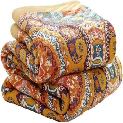 Medallion throw blanket folded in a stack, orange, mustard and teal paisley print with a mustard border