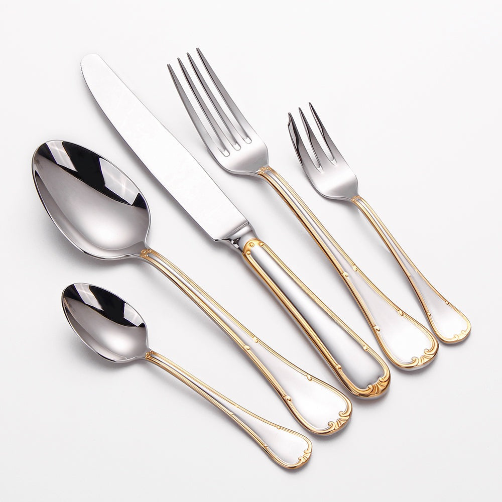 Gold trim flatware place setting on white: dinner spoon, dinner knife, dinner fork, cake fork and teaspoon in mirror-polished steel