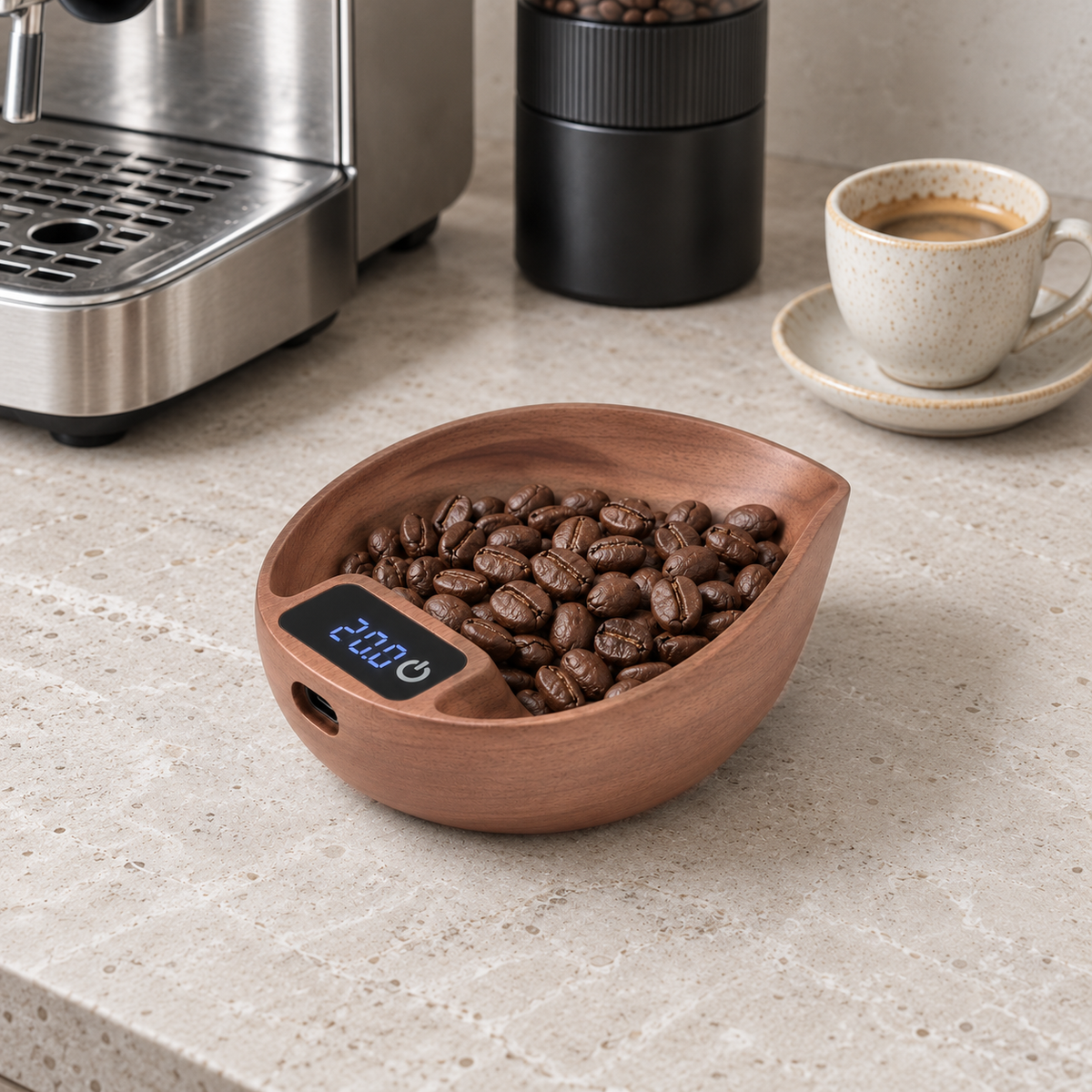 Leaf-shaped walnut coffee scale holding a dose of coffee beans, its display reading 20.0, on a pale stone coffee counter beside an espresso machine