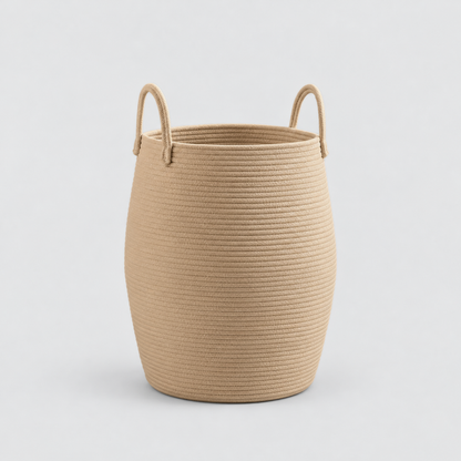 A tan rope laundry hamper with two rope handles, standing empty on a light grey background.