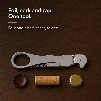 Folded stainless steel waiter's corkscrew on a dark walnut table above a cut wine foil capsule, a wine cork and a gold crown bottle cap laid in a row at true relative size