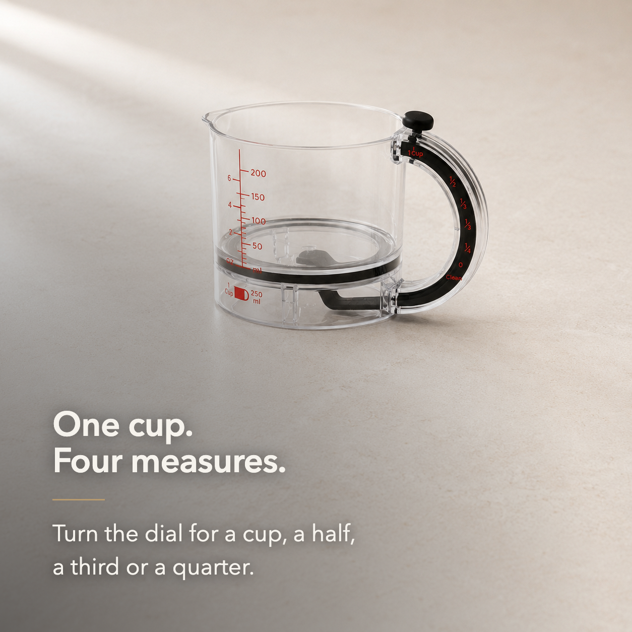Clear adjustable measuring cup standing empty on a pale stone worktop with the handle facing the camera, the black dial knob on top and the red settings printed down the handle