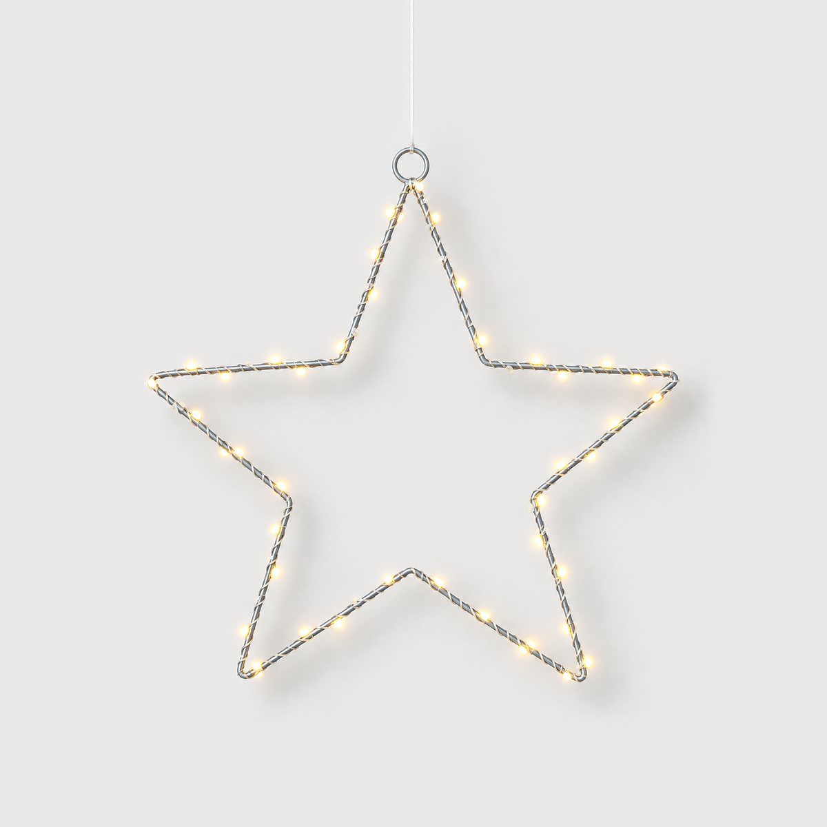 LED star light hanging from its top ring, its warm white beads lit, on a light gray background