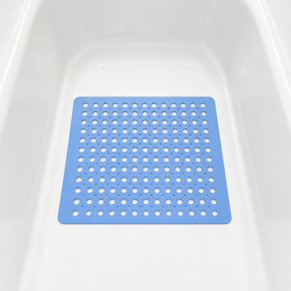 Blue non slip shower mat with drainage holes lying in the base of a white bathtub