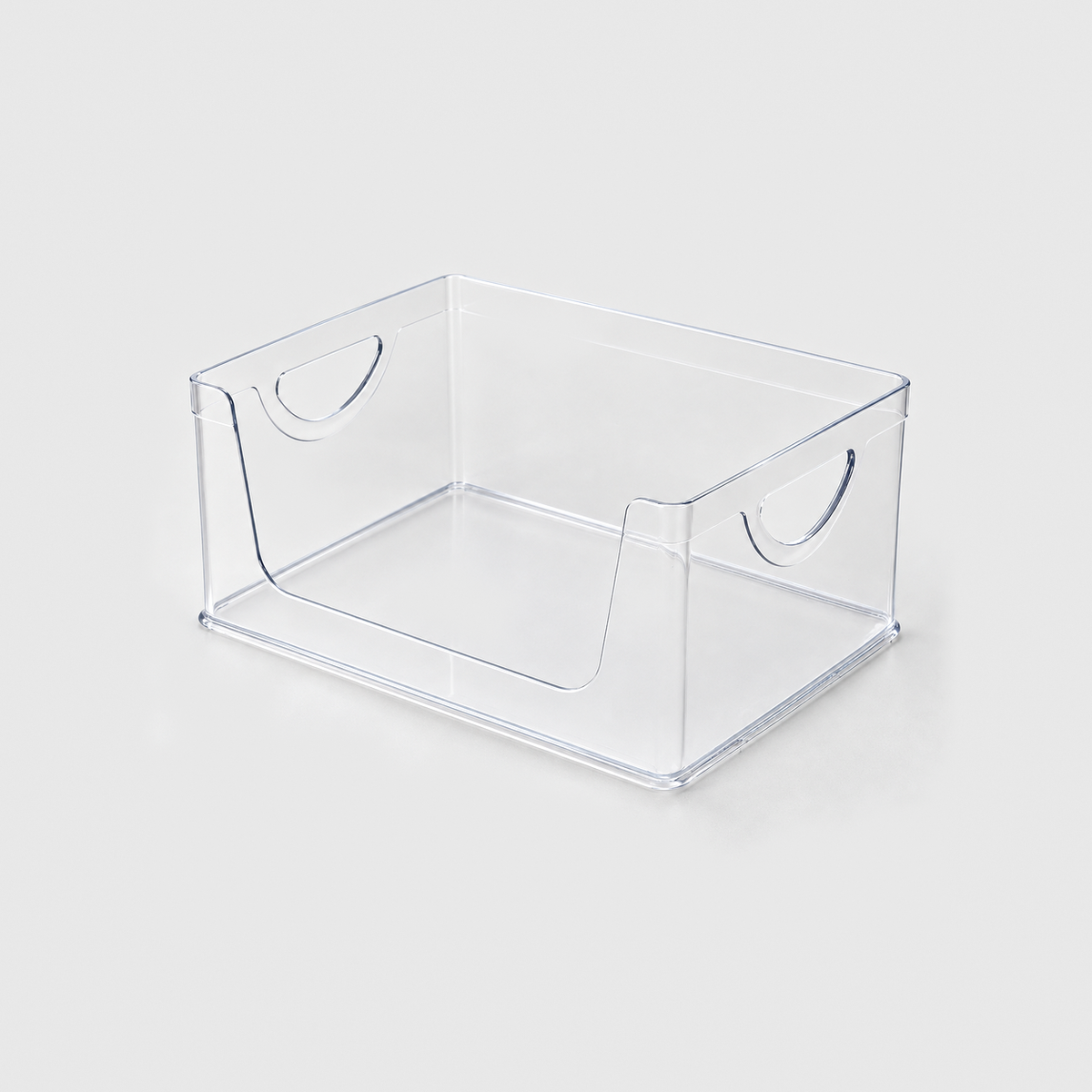 Empty clear open-front pantry bin on a light grey background, three-quarter view showing the open front and a half-moon handle cut-out