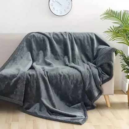 Gray plush throw draped over a light couch with a sherpa corner turned back