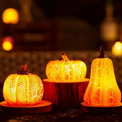 Three lit resin pumpkin lights on wood rounds with candles behind