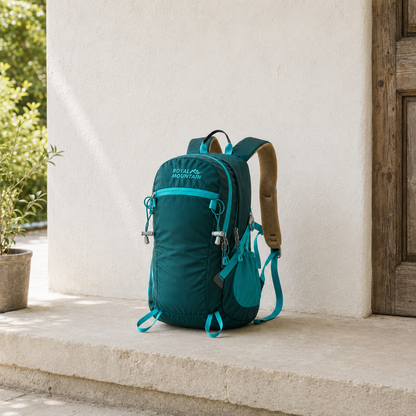 Dark green 30L hiking day pack with teal trim standing on a stone porch step in daylight