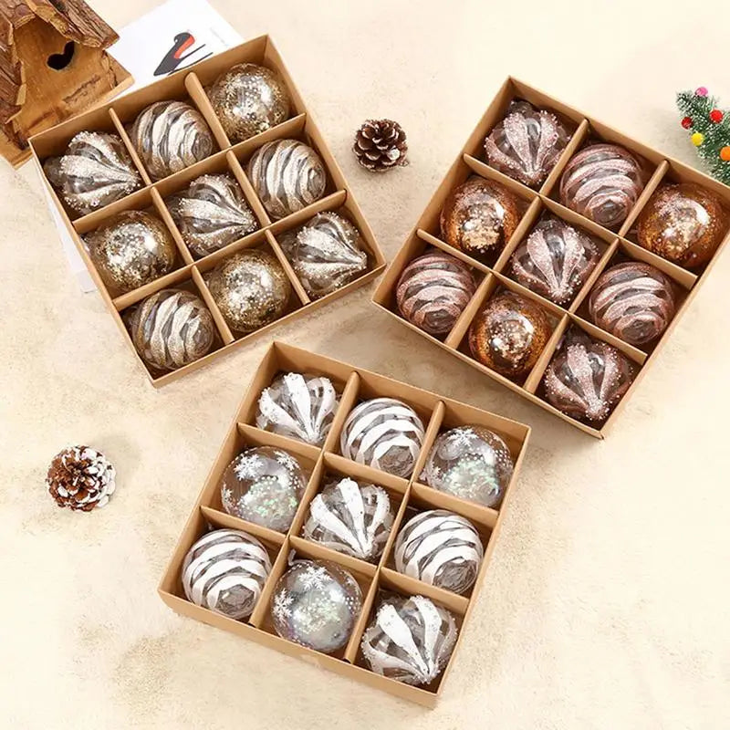 Three boxes of glitter baubles in white, rose gold and champagne on a cream cloth with pine cones