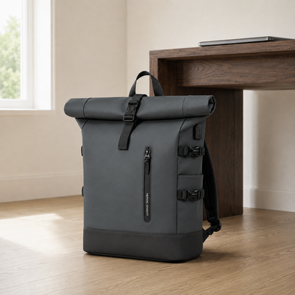 Gray roll top backpack on an oak floor beside a walnut desk in a daylit home office