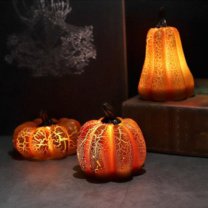 Three LED pumpkin lights glowing on a dark stone surface in the evening