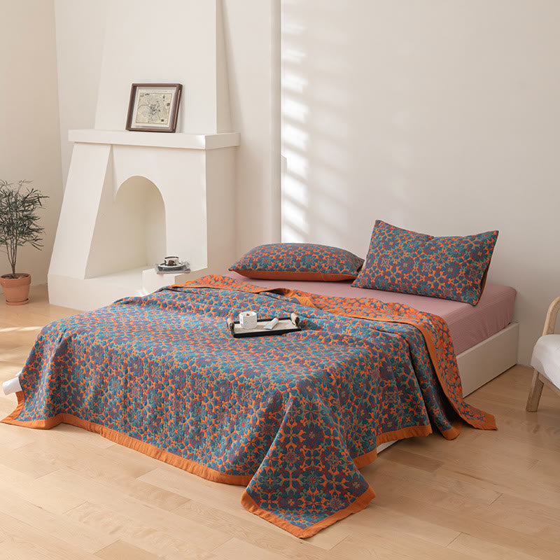 Reversible orange and blue quilt and matching pillowcases on a bed in a bright bedroom