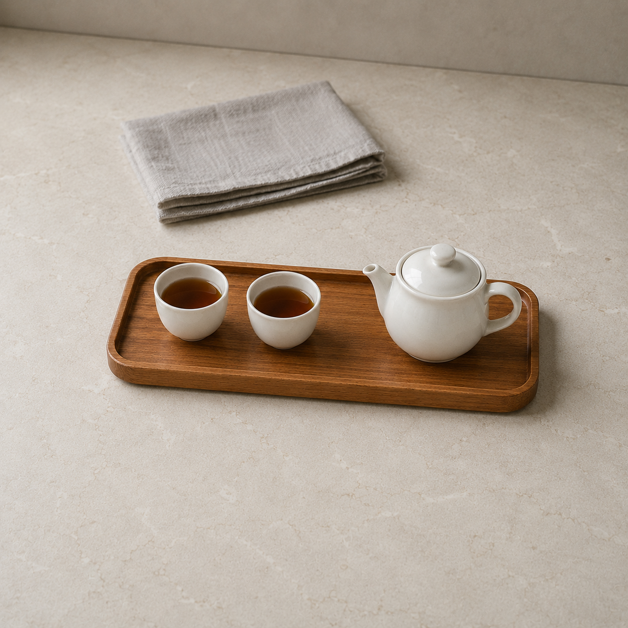 Large rectangular wooden tray on a kitchen counter with a teapot and two cups