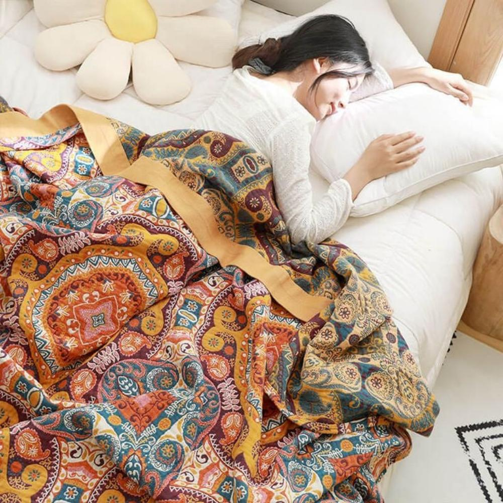 Reversible throw blanket on a bed with one corner turned over to show the darker teal patterned reverse