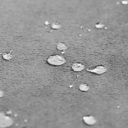 Drops of water sitting in round beads on the gray plush face of the blanket
