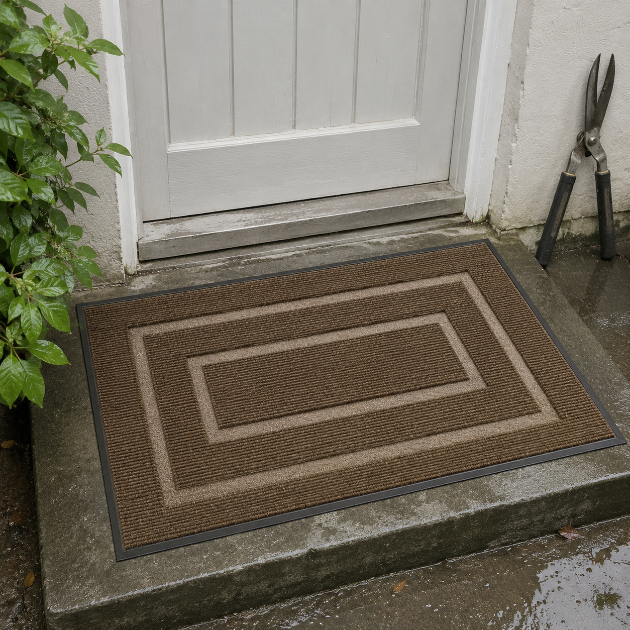 Brown door mat on a damp concrete back step after rain, beside a white painted door.