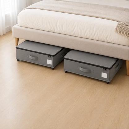 Two gray under bed storage boxes side by side in the clear space beneath a double bed.