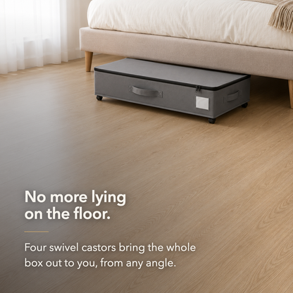 Gray under bed storage box rolled out from under a bed on its four swivel castors, with clear floor around it.