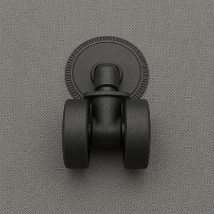 Close-up of one black swivel castor seated in its round socket plate on the gray fabric base of the box.