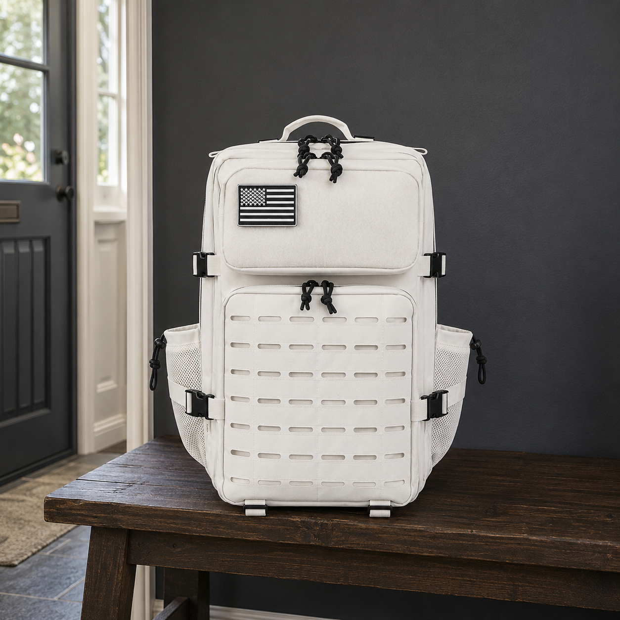 Off white laser cut MOLLE tactical backpack on a dark oak hall bench