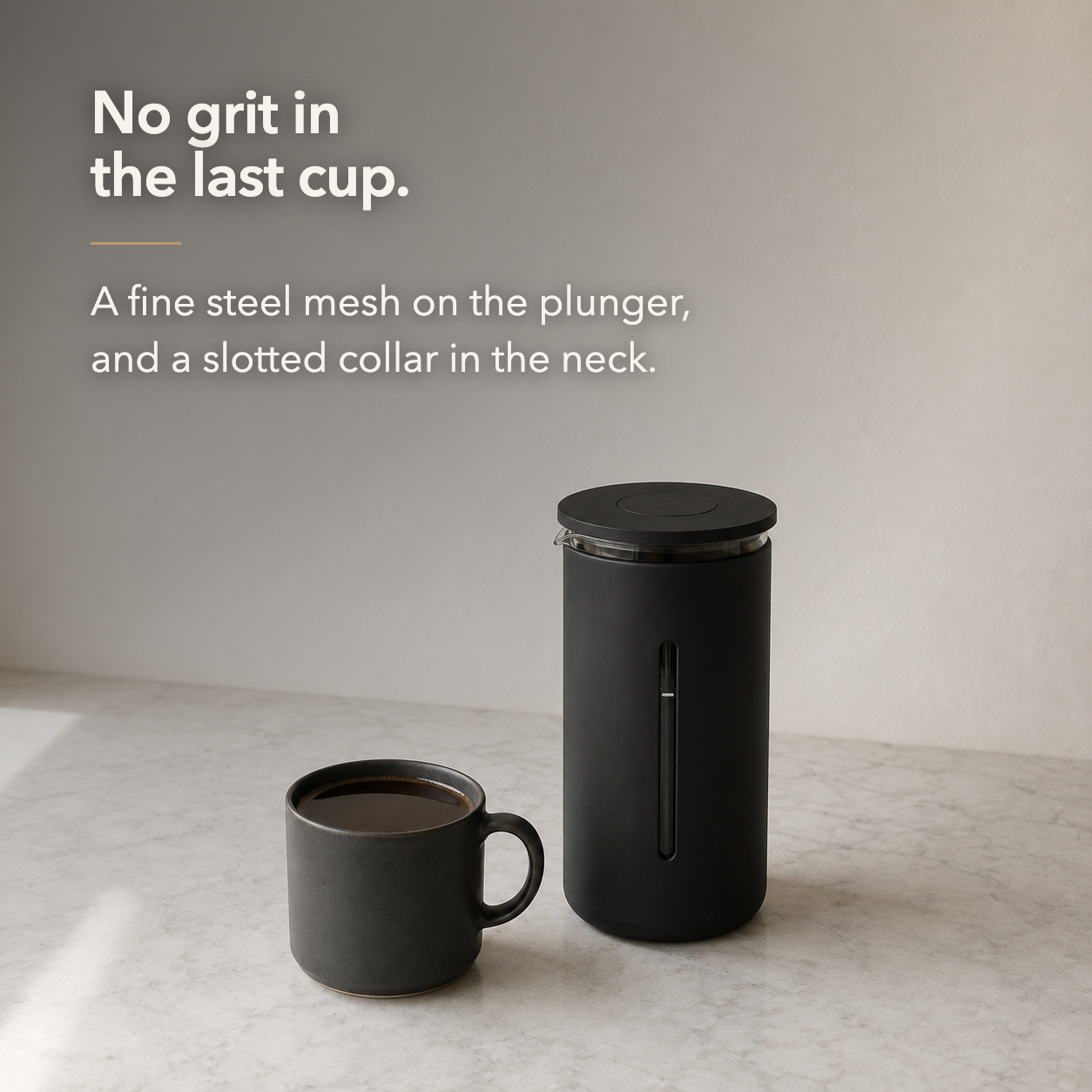 A mug of clean black coffee poured from the French press on a marble worktop.