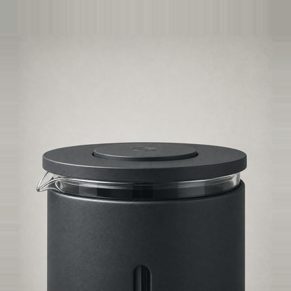 Close-up of the French press lid, its raised press knob and the clear glass pour lip.