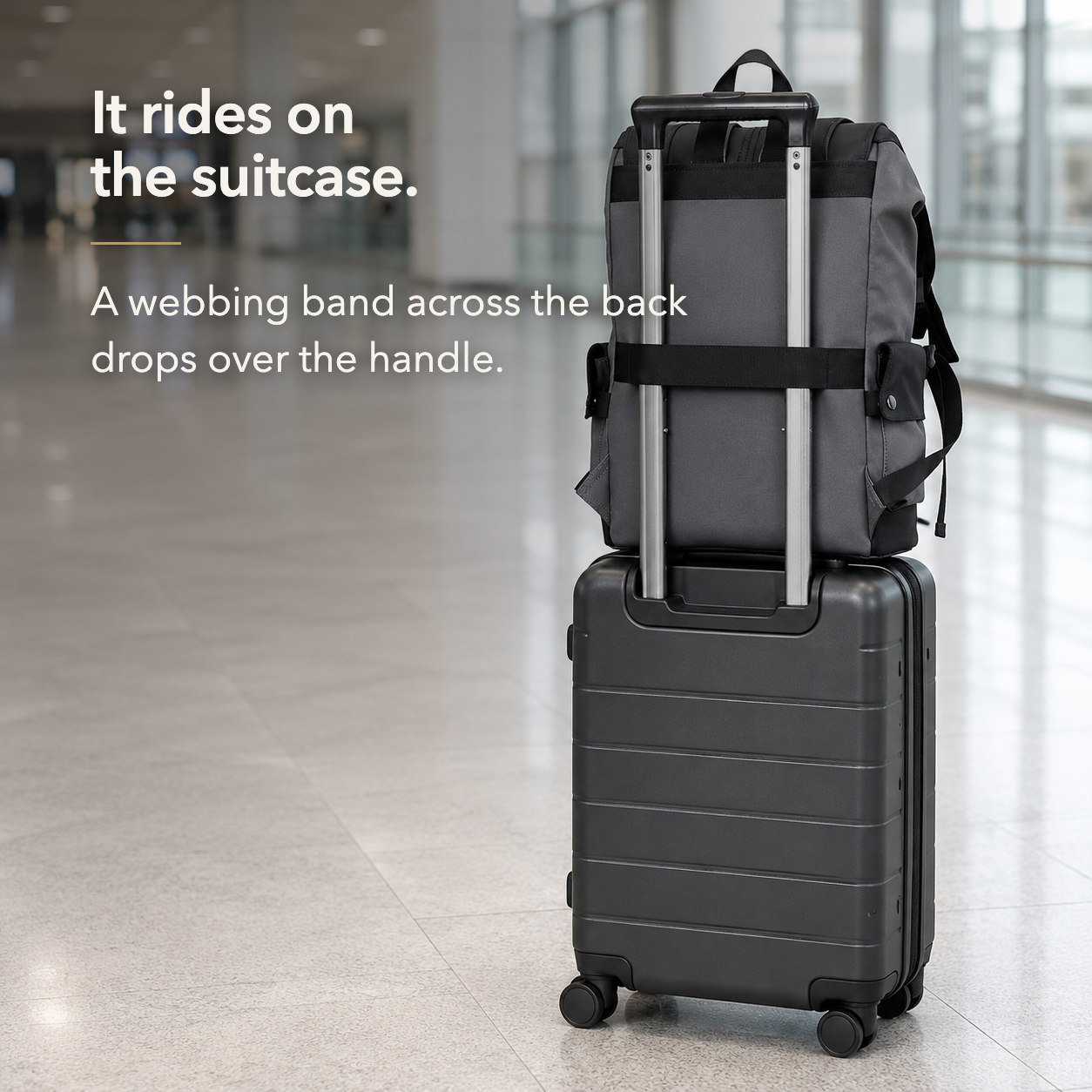 The backpack's rear webbing band dropped over the extended handle of a wheeled suitcase