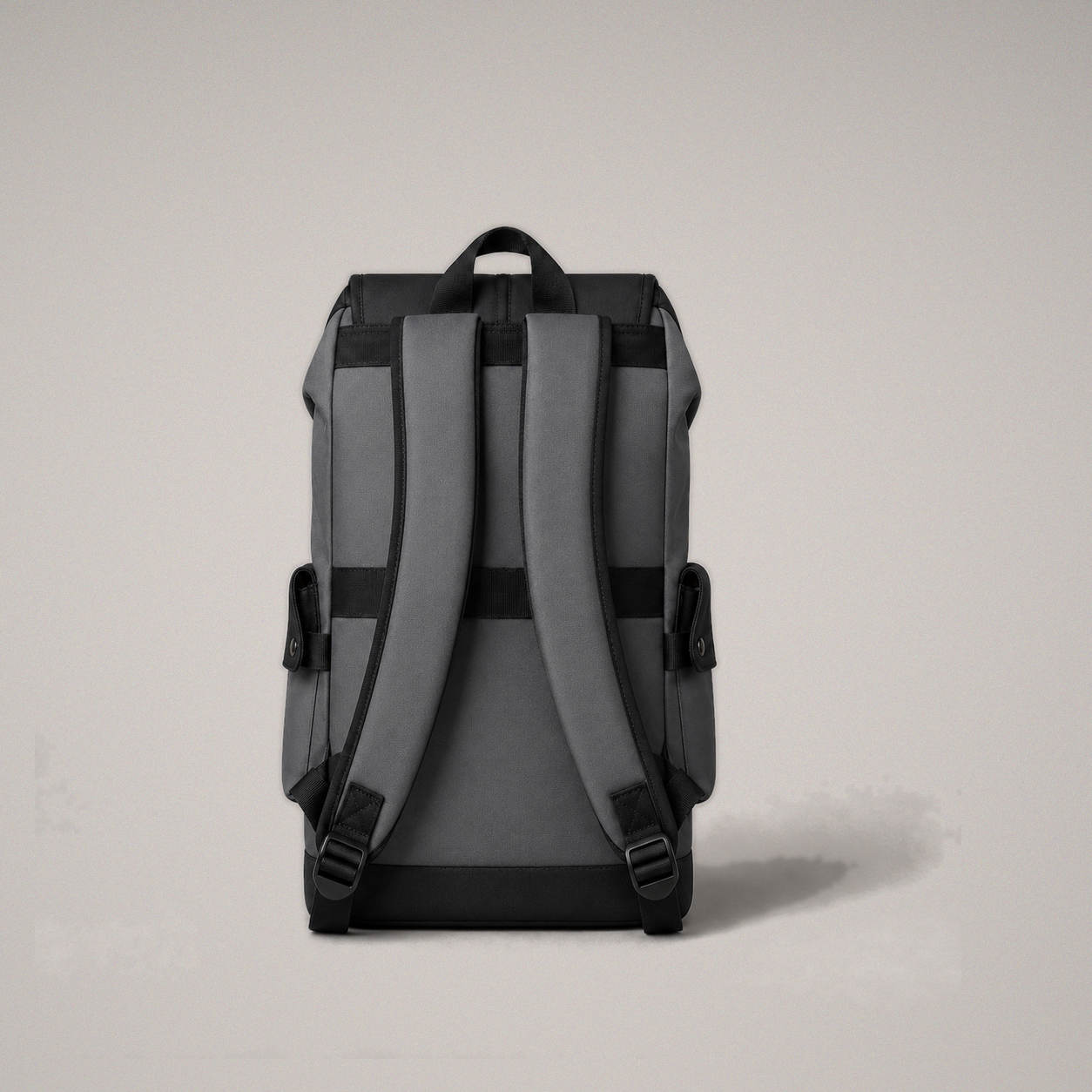 Studio rear view of the black and gray backpack showing the padded straps, grab handle and luggage band