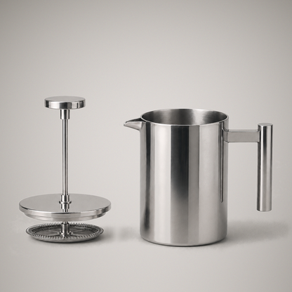 The plunger assembly lifted out and standing beside the open pot, showing the rod, lid, coil spring and woven mesh filter screen