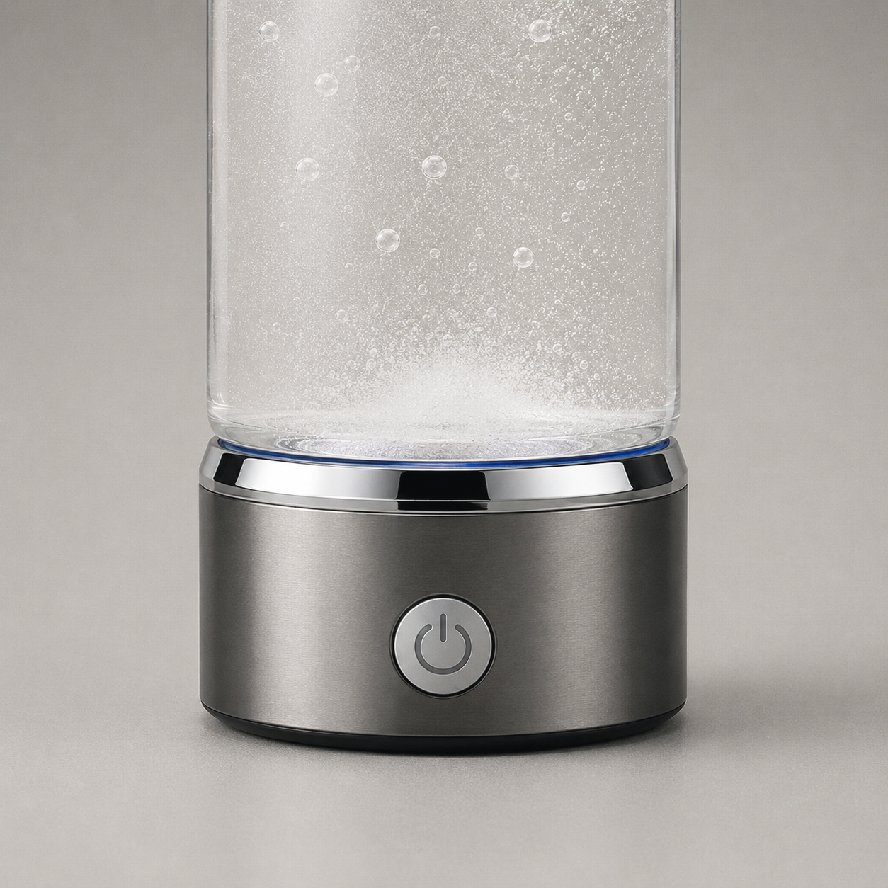 Close view of the base collar showing the single round power button with its power symbol, the polished rim above it and a fine blue line at the joint