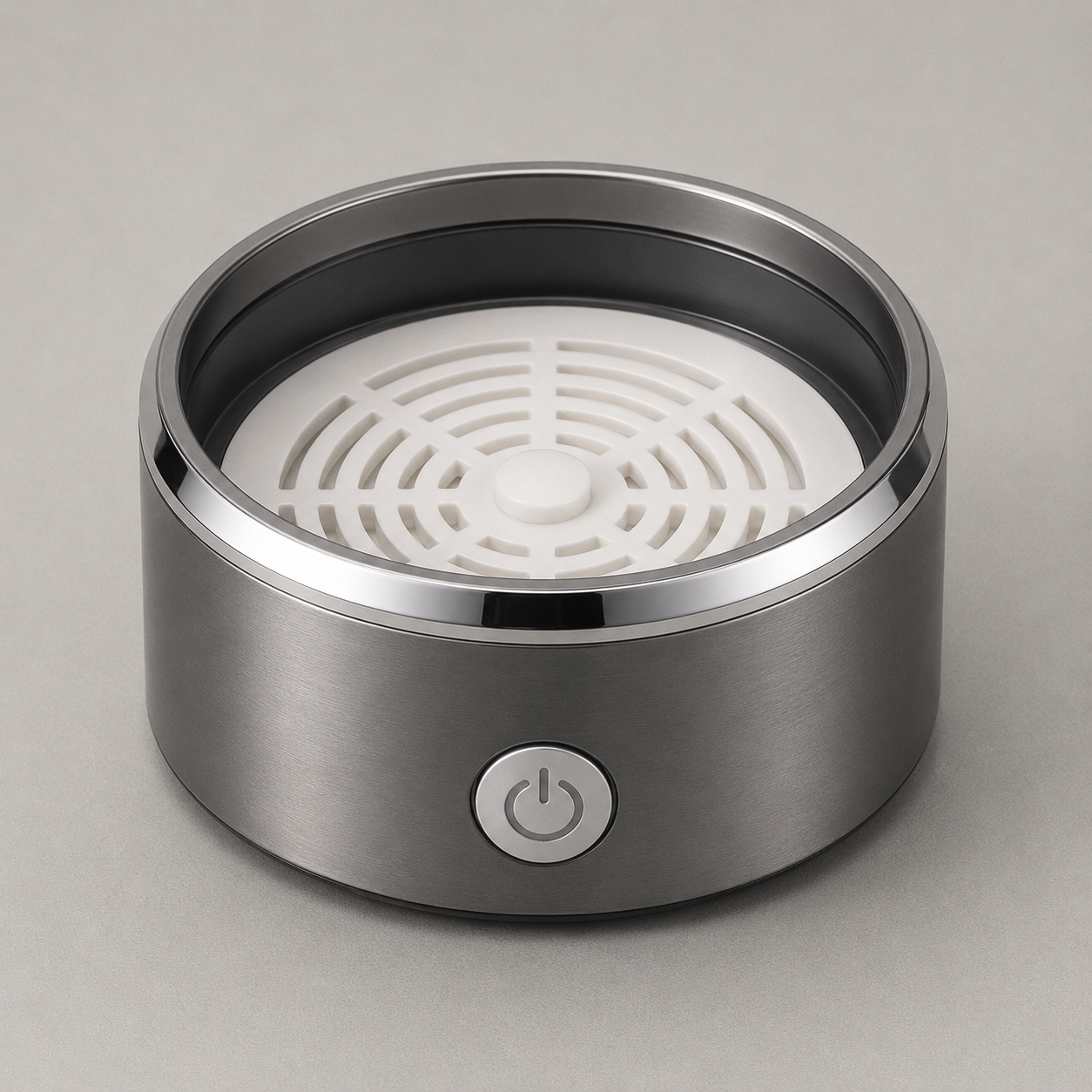 The metal base with the barrel lifted off, looking down at the white slotted plate in the floor of the chamber and the small boss at its centre