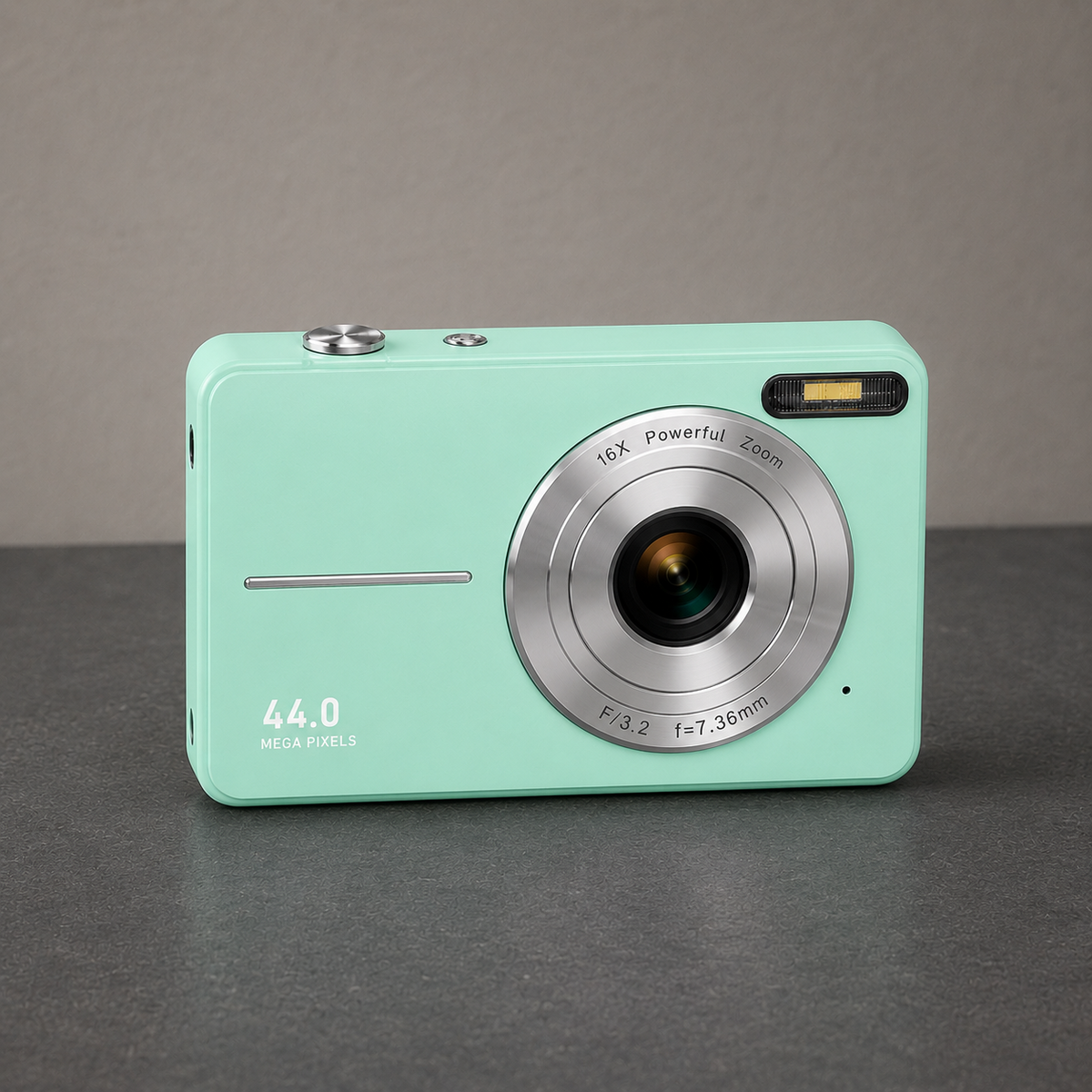 Green compact digital camera standing on a dark slate hallway counter against a plain grey wall, seen from the front at a slight angle, with the silver lens ring, the flash window at the top right and 44.0 MEGA PIXELS on the lower left of the body