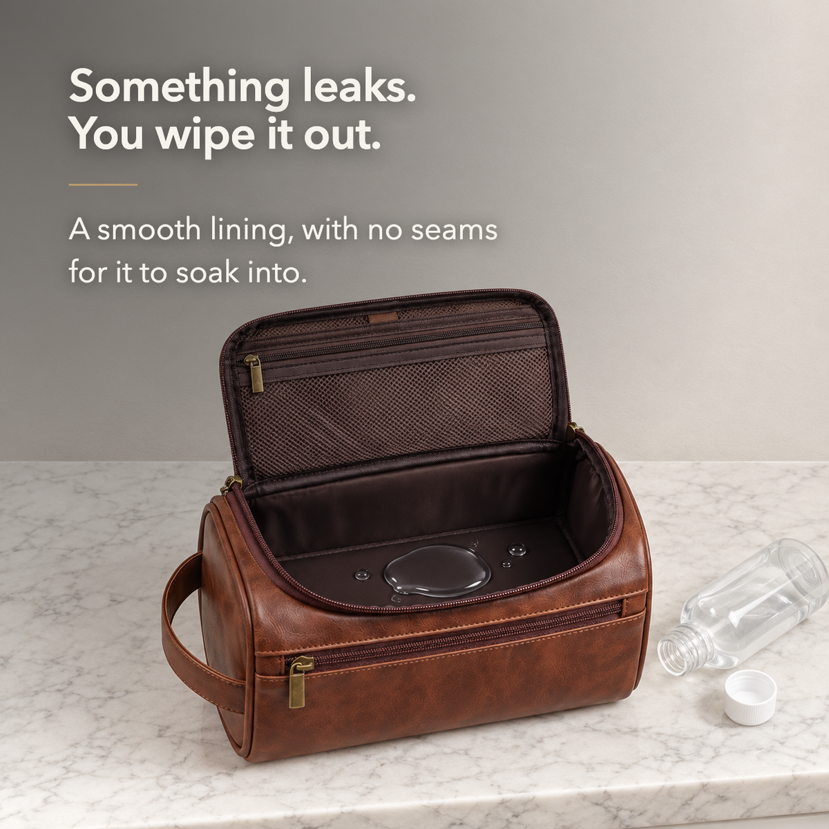 Brown toiletry bag open on a marble counter with liquid pooled on its lining and a bottle on its side, below the words Something leaks. You wipe it out