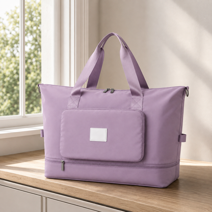 Purple foldable travel bag on a bedroom window seat in daylight, with twin webbing carry handles
