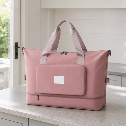 Pink foldable travel bag on a kitchen worktop in daylight, with mauve webbing carry handles