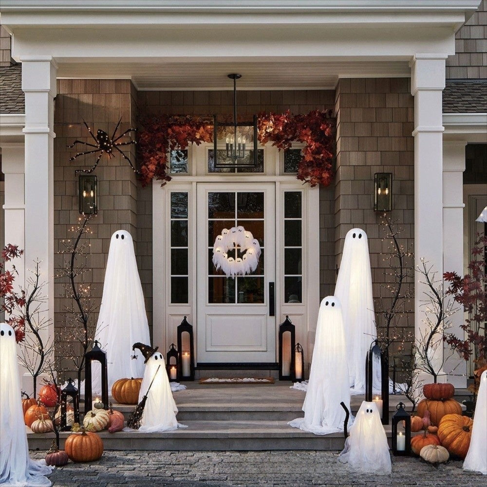 Ghost wreath on a front door of a porch decorated for Halloween