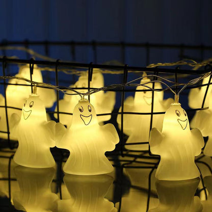 Ghost string lights lit along a black wire fence against a blue evening sky