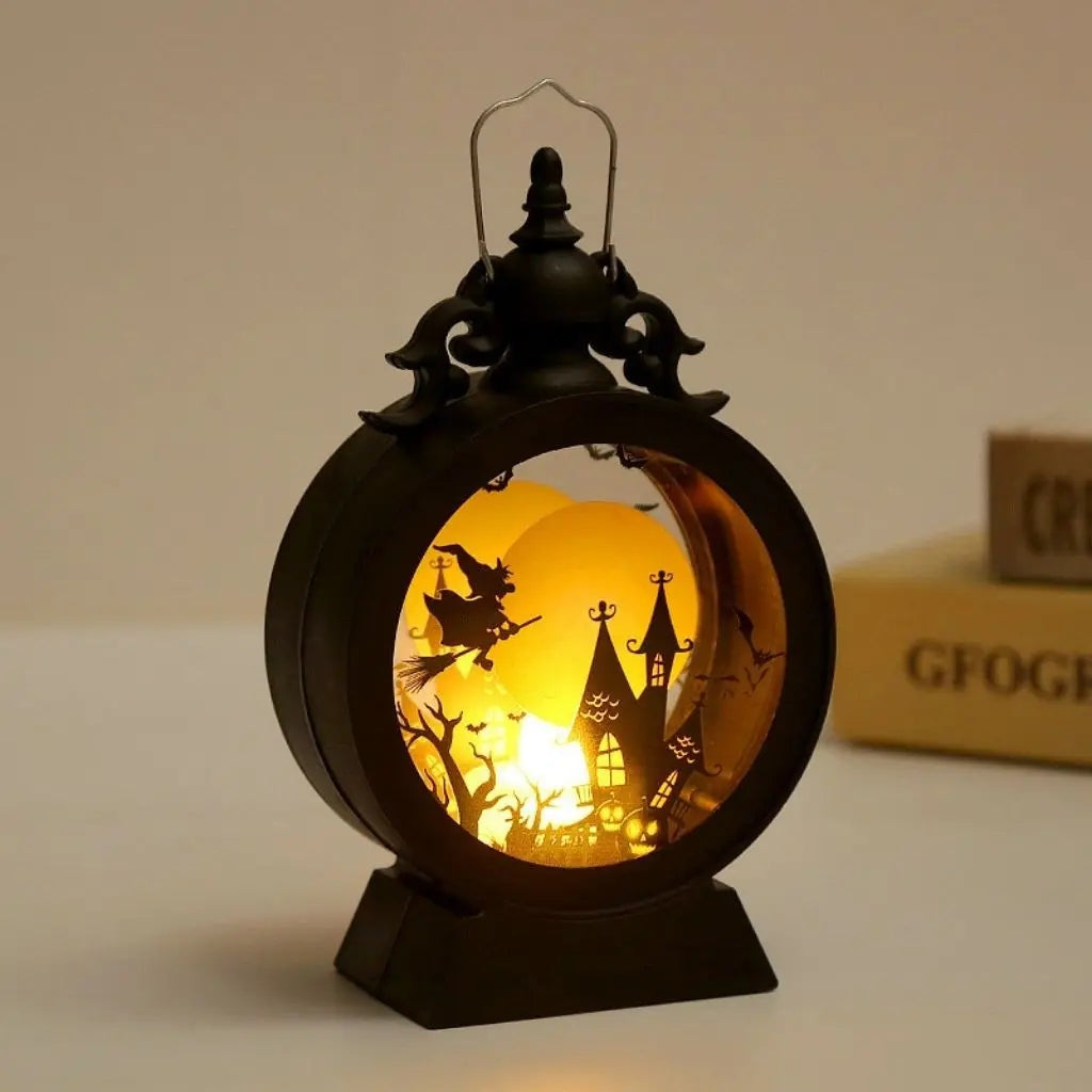 Halloween lantern with the witch scene lit, standing on a table beside books