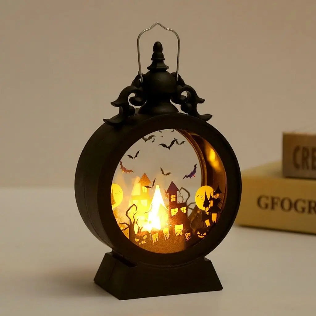 Halloween lantern with the castle scene lit, standing on a table beside books