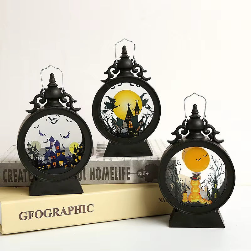 Three Halloween lanterns switched off in daylight, showing the printed scenes in their true colours