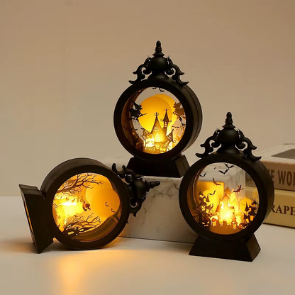 Three lit Halloween lanterns with one tipped onto its side, showing the outer drum, the solid back and the base