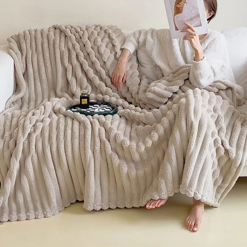 Beige pleated faux fur throw spread over a white sofa, with someone reading under one end
