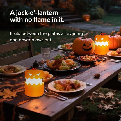 Two lit pumpkin lanterns on an outdoor dinner table beside a carved pumpkin
