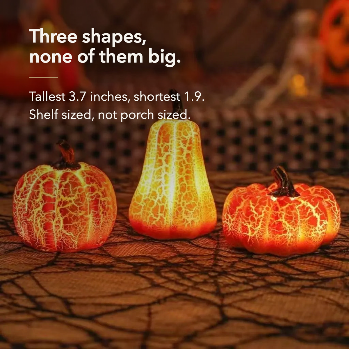 Three lit pumpkin lights side by side with their heights given