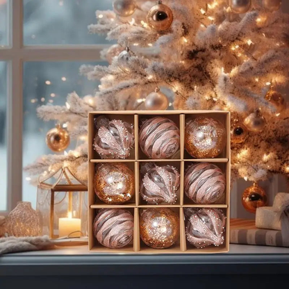 Rose gold glitter baubles in their box in front of a frosted Christmas tree by a window